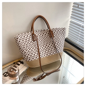 Detail of bohemian woven tote bag showing mixed knit patterns and brown leather handles