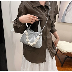 Detail of silver velvet cloud bag with large faux pearl handle and metal chain strap