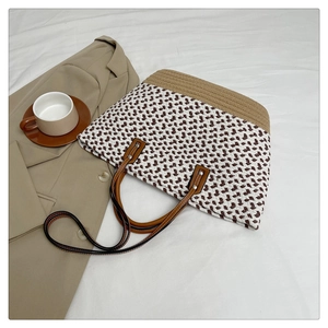 Detail of bohemian woven tote bag showing white coffee pattern and leather handles