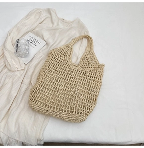 Detailed close-up of handmade straw tote bag with woven hollow mesh and cotton cord texture