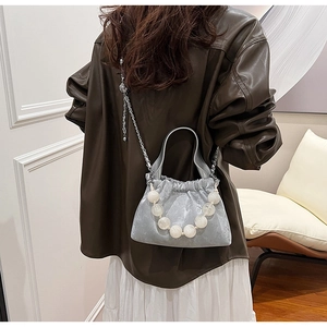 Detail of silver PU leather bag with large bead handle and metallic chain strap