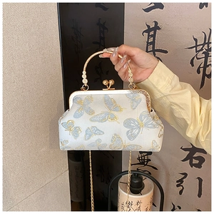 Détail d'un sac en soie vintage avec jacquard papillon bleu et fermoir à baiser doré