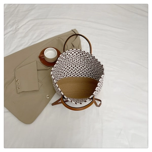 Detailed top view of handmade woven tote bag with wavy patterns and leather handles