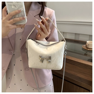 Détail du sac bandoulière élégant en cuir PU crème avec boucle nœud argenté et chaîne
