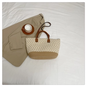 Detail of bohemian handmade woven tote bag with contrast stitching and leather handles