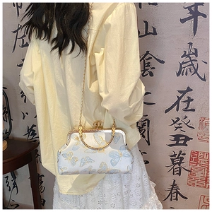 Détail du sac bandoulière en soie vintage avec broderie papillon et fermoir doré