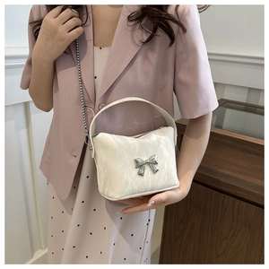 Détail du sac à bandoulière en cuir PU crème texturé avec boucle de nœud en métal argent