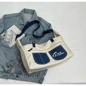 Japanese style white canvas messenger bag with blue denim pockets and nylon strap