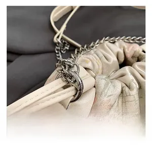 Detail view of the silver metal chain and swivel hook on the floral silk crossbody bag