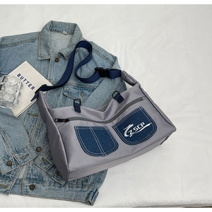 Minimalist canvas crossbody bag with blue denim pockets and adjustable strap