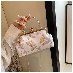 Détail du sac bandoulière en soie avec broderie papillon et poignée ronde dorée