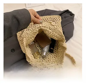 Top view of spacious straw shoulder bag interior showing daily essentials like a phone