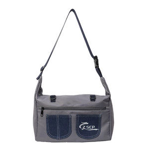 Minimalist grey nylon crossbody bag with blue denim pockets and adjustable strap
