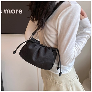 Detail of black silk shoulder bag featuring bamboo leaf pattern and metal chain strap
