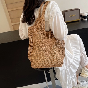 Brown hand-woven straw mesh tote bag with wide shoulder strap in Bohemian summer style