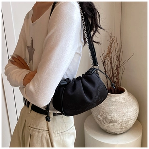Detail of black pleated cloud bag with bamboo pattern texture and silver chain strap