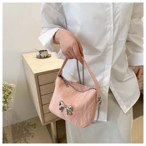 Détail du sac à bandoulière rose clair en PU avec texture plissée et boucle nœud argenté