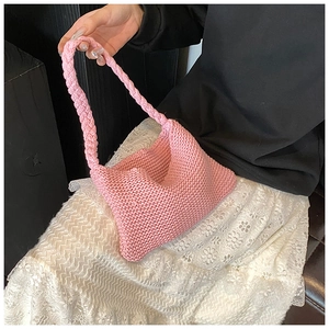 Close-up of pink knitted tote bag showing detailed crochet texture and soft woven handle