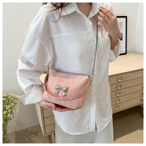 Détail du sac à bandoulière rose en cuir PU avec nœud en métal argenté et chaîne