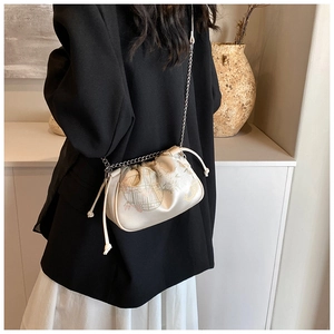 Detail of cream silk shoulder bag with elegant bird and flower prints on satin material