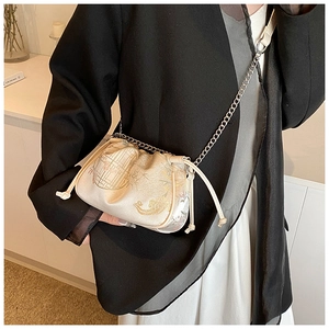 Detail of embroidered silk crossbody bag featuring floral patterns and a metal chain strap