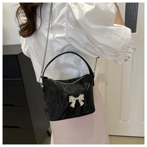 Détail du sac bandoulière en PU plissé noir avec nœud argenté et bandoulière chaîne