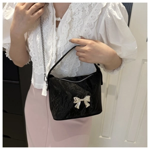 Détail du sac à main noir plissé en PU avec nœud argenté et bandoulière en chaîne