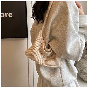 Detail of hand-crocheted knitted shoulder bag showing delicate diamond texture in cream white