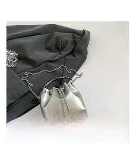Detail view of silver bucket bag with vertical stripe pattern and metal chain strap