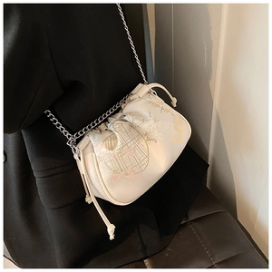 Detail of cream white silk cloud bag with floral embroidery and thin metal chain strap
