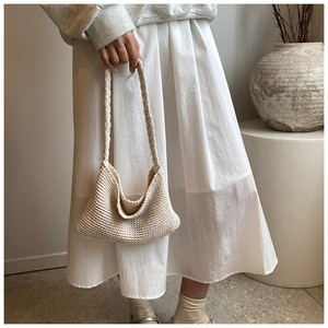 Close-up detail of beige knitted tote bag showing honeycomb texture and soft cotton fabric