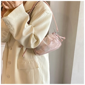 Pink floral jacquard mini shoulder bag with chain strap styled on a beige blazer