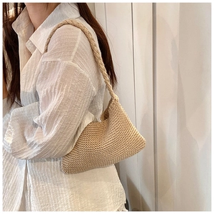 Detailed close-up of beige knitted texture and soft shoulder strap on women's bag