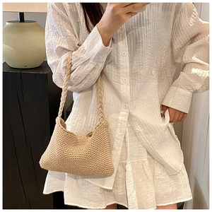 Detail of hand-woven beige knit shoulder bag with textured cotton rope strap craftsmanship