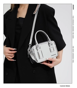 Close-up of silver mirror PU crossbody bag with brand logo and adjustable strap details