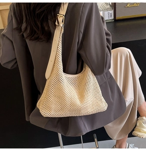 Minimalist beige woven hobo bag with adjustable leather strap shown as worn