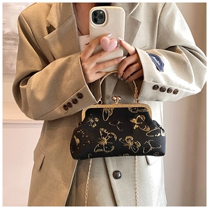 Detail of black satin shell bag with gold butterfly embroidery and vintage metal handle