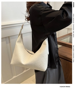 Detail of white woven PU leather hobo bag with adjustable shoulder strap on female model