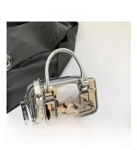 Detailed close-up of a silver mirror finish PU handbag with rounded handle and metal zipper