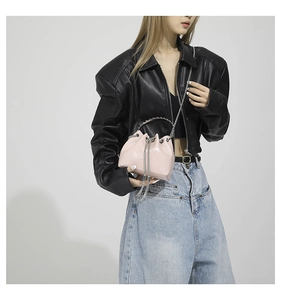 Detail of pink glossy PU leather bucket bag with silver chain strap and metal ring handle