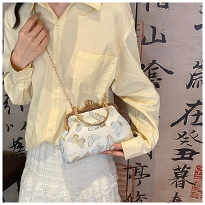 Détail du sac de soirée en soie vintage avec broderie papillon bleue et bandoulière chaîne