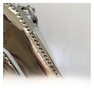 Detail of silver metallic PU leather surface with precise stitching and reflective finish