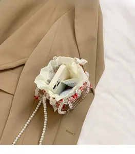 Close-up of beaded handbag interior with white satin drawstring liner and pearl strap