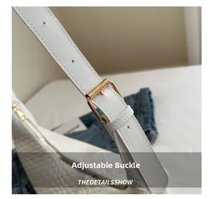 Detail of adjustable PU leather shoulder strap with golden metal buckle on woven white bag
