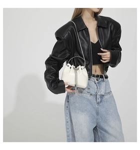 Detail of white PU leather bucket bag featuring silver chain fringe and drawstring closure