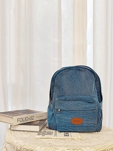 Detailed macro view of denim backpack textured fabric and brown leather brand logo