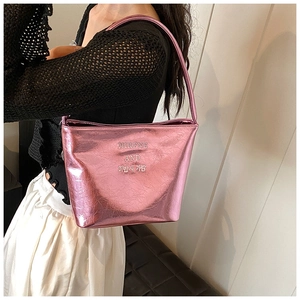 Détail du sac seau rose métallisé avec texture craquelée et bandoulière sur mannequin