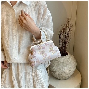 Détail du sac nuage en soie blanche avec broderie papillon et fermoir doré