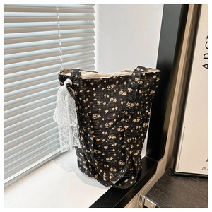 Grand cabas vintage à fleurs noires avec ruban de dentelle blanche sous la lumière