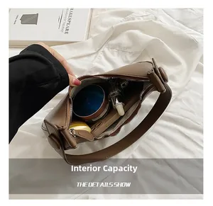 Detail view of the brown leather shoulder bag interior showing storage capacity and items
